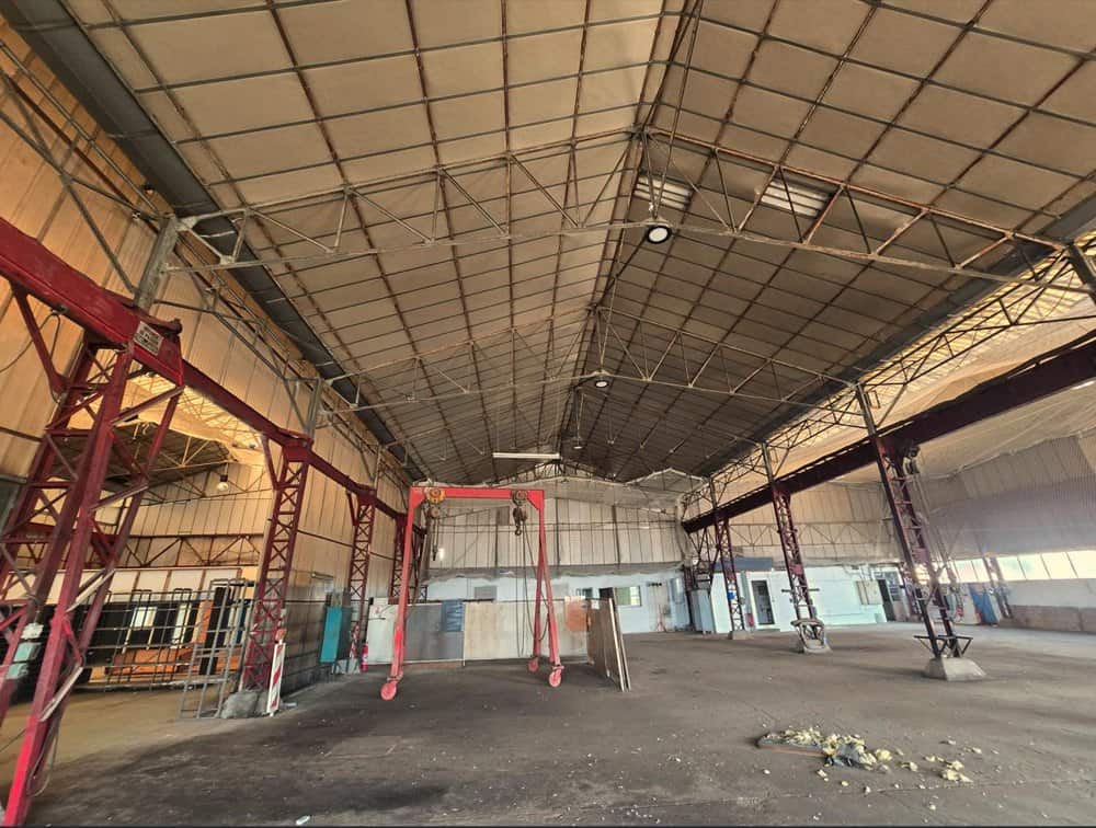 Intérieur d'une halle industrielle avec charpente métallique en treillis