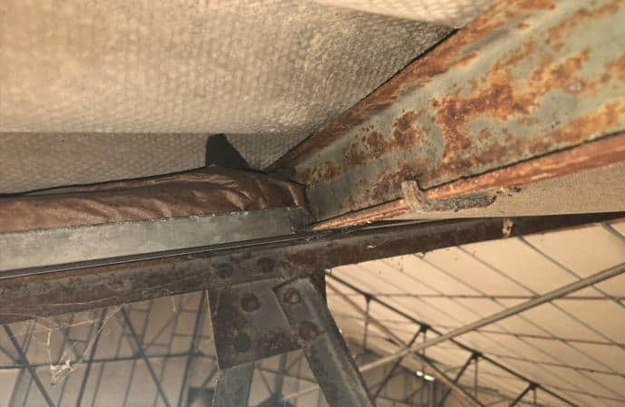 Corrosion superficielle d'une membrure de charpente métallique au-dessus du filet de protection
